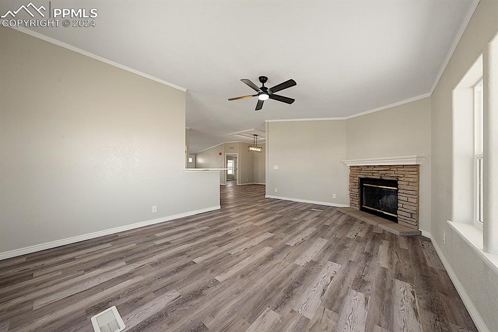 8160 Edison Road Yoder, CO 80864 - Photo 14 of 42 a view of empty room with a fireplace and wooden floor