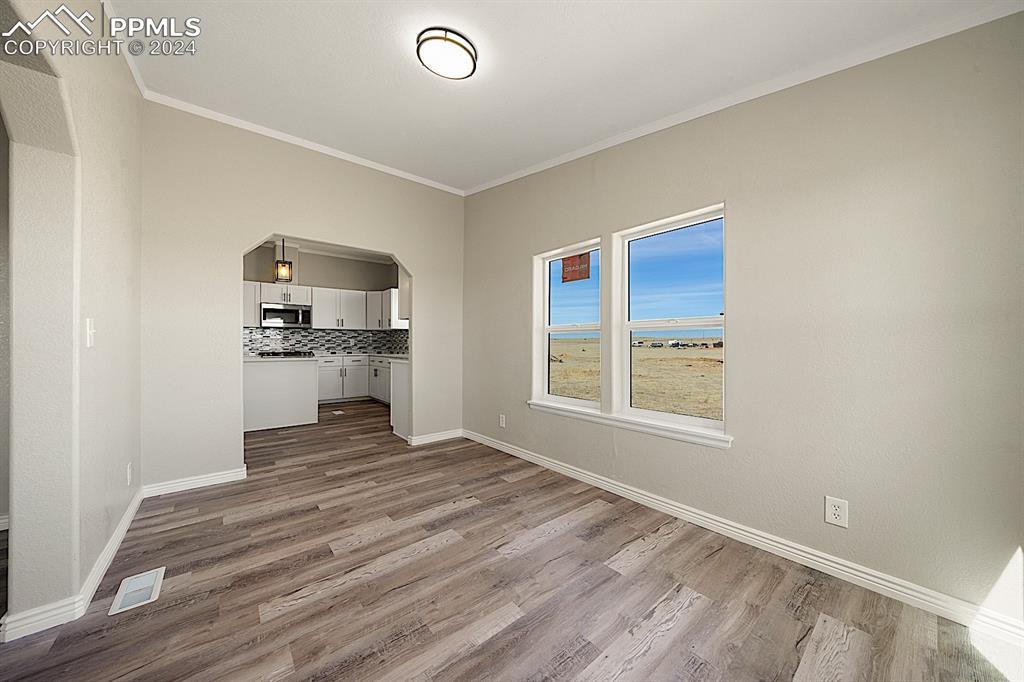 8160 Edison Road Yoder, CO 80864 - Photo 18 of 42 a view of kitchen and empty room with wooden floor