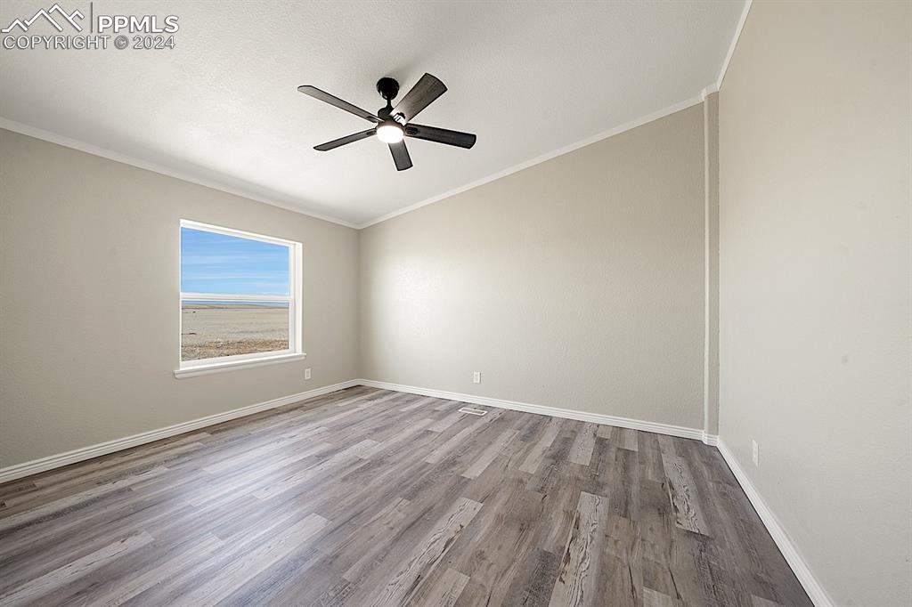 8160 Edison Road Yoder, CO 80864 - Photo 28 of 42 a view of empty room with wooden floor and fan