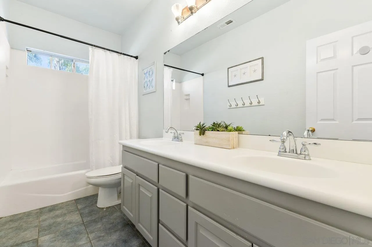 640 Rowley Way Ramona, CA 92065 - Photo 28 of 39 a bathroom with a granite countertop sink a toilet and a mirror