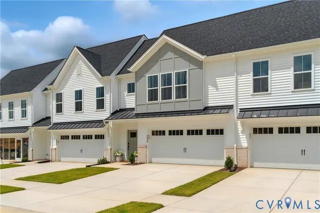 a front view of a house with a garden and parking