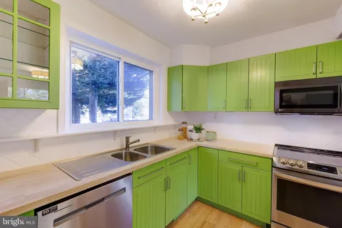 a kitchen with a sink a stove and cabinets