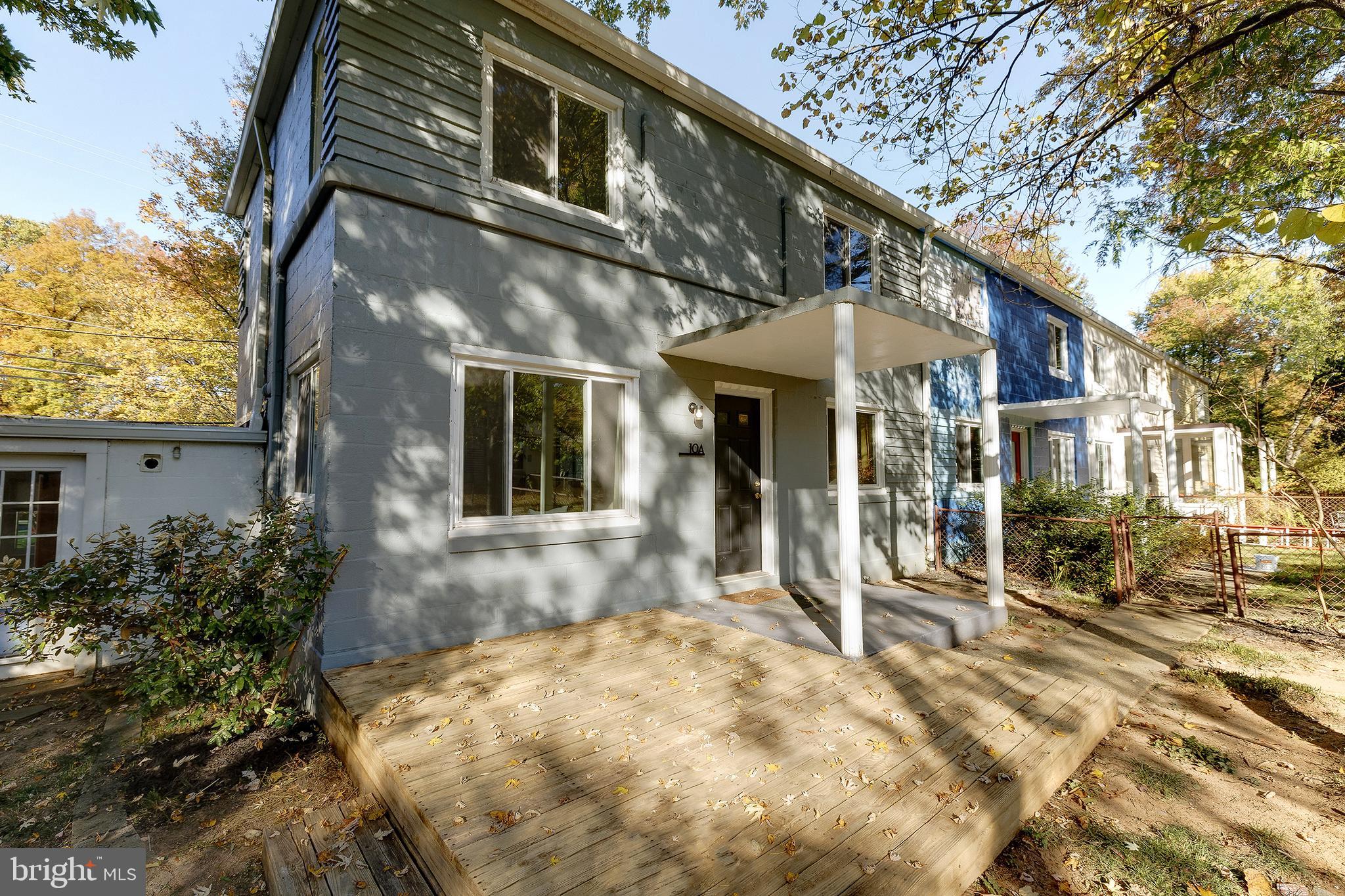 10 Hillside Road Greenbelt, MD 20770 - Photo 5 of 50 a view of a white house with large windows and a table and chairs