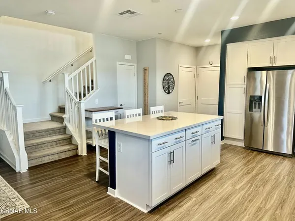 a kitchen with a sink cabinets stainless steel appliances and wooden floor