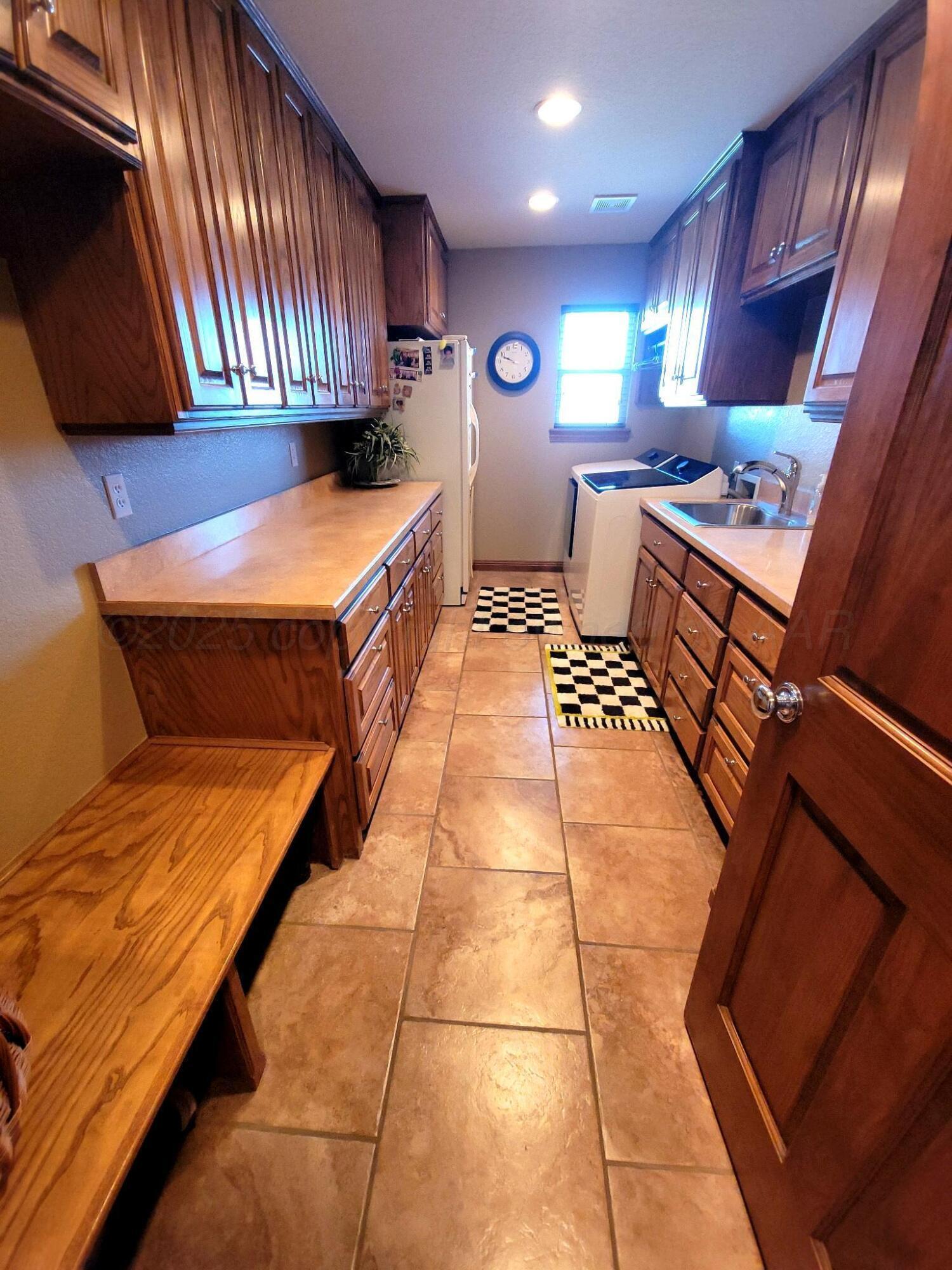 14355 Southeast Se Loop Perryton, TX 79070 - Photo 20 of 33 a kitchen with stainless steel appliances kitchen island granite countertop a stove a sink and a microwave