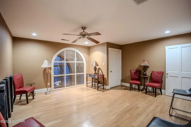 a room with stainless steel appliances kitchen island a large window and a sink in it