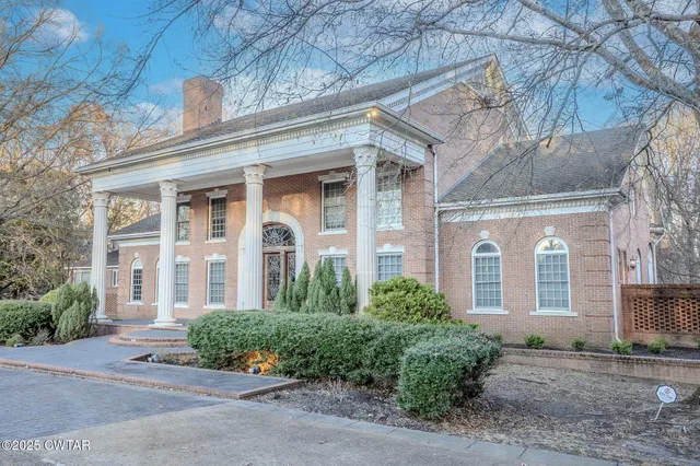 front view of a brick house with a small yard