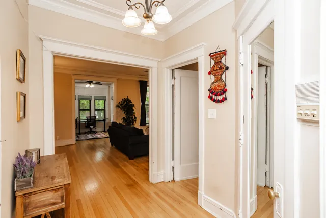 a view of a livingroom with wooden floor and a chandelier