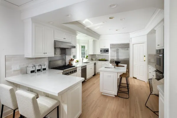 a kitchen with a sink a counter top space stainless steel appliances and cabinets