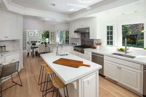 a kitchen with stainless steel appliances granite countertop a sink a stove and a refrigerator