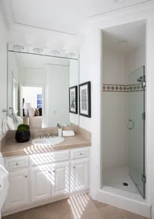 a bathroom with a double vanity sink mirror and shower