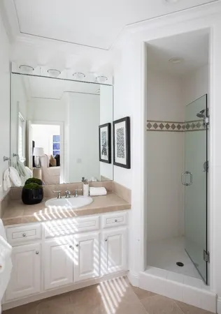 a bathroom with a double vanity sink mirror and shower