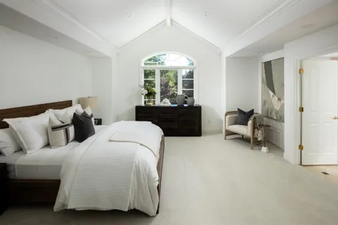 a bed room with a bed and a chair