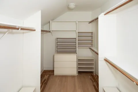 a view of walk in closet with empty racks