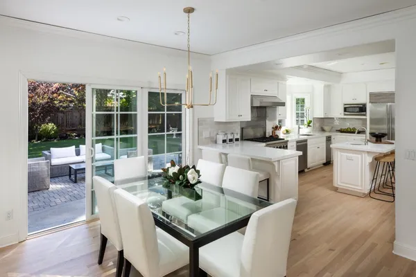 a dining room with kitchen island furniture a large window and stainless steel appliances