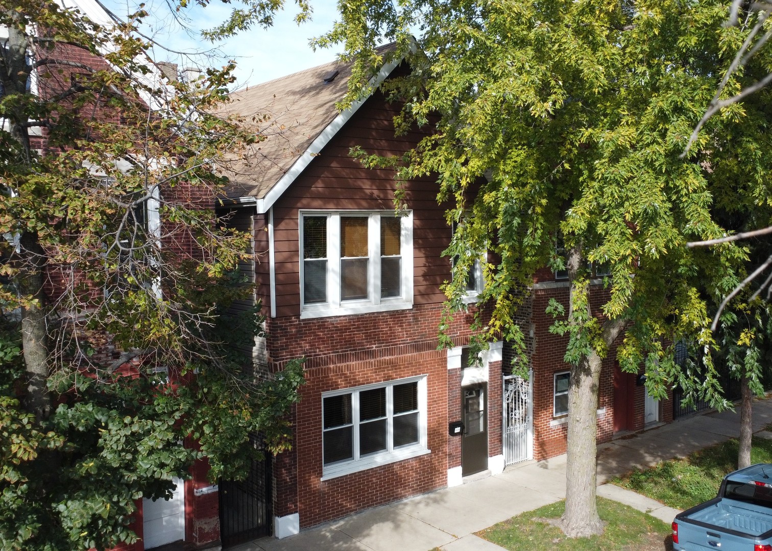 a front view of a house with a tree