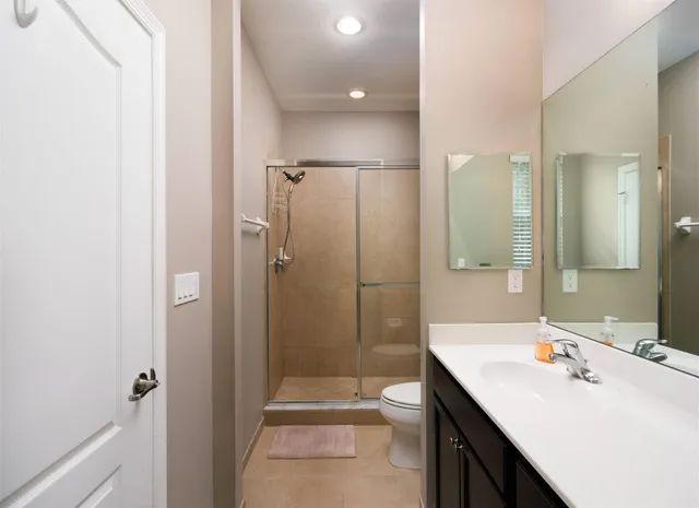 a bathroom with a sink a toilet and shower