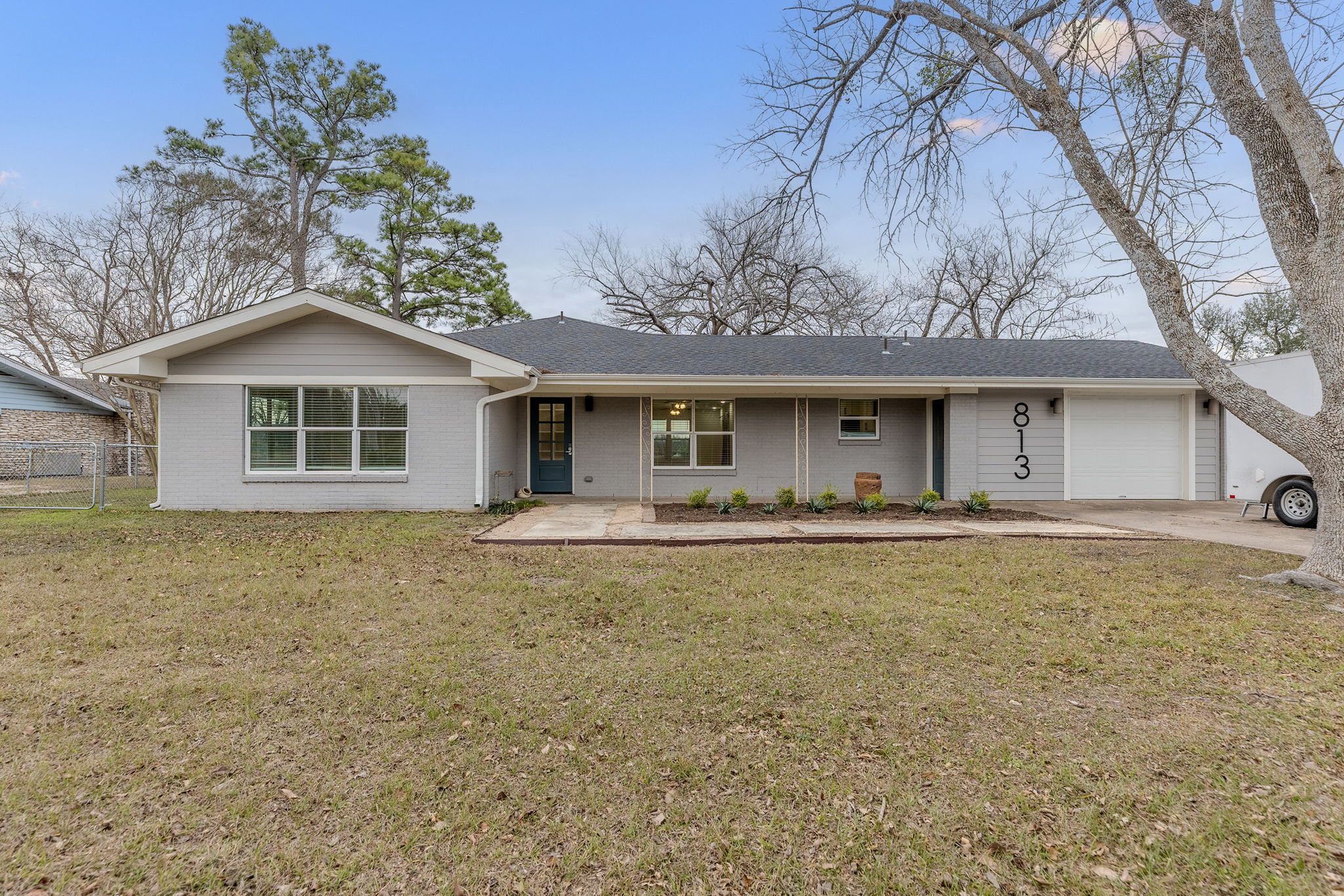 813 Central Avenue Elgin, TX 78621 - Photo 3 of 22 Ranch-style home featuring covered porch, brick siding, driveway, an attached garage, and a shingled roof