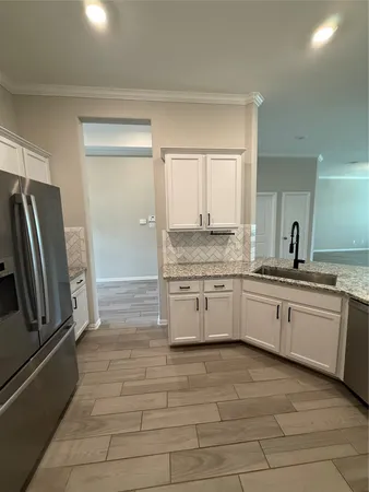 a large kitchen with granite countertop a refrigerator and a sink