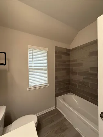 a bathroom with a bathtub and a toilet