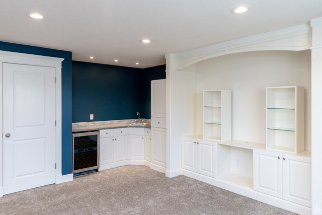 434 Cardon Ridge Drive Smithfield, UT 84335 - Photo 38 of 59 Indoor wet bar with beverage cooler, white cabinets, light carpet, recessed lighting, and light countertops