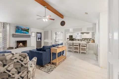 a living room with furniture a fireplace and a ceiling fan
