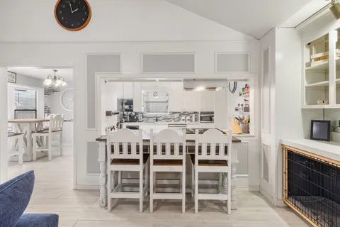 a dining room with a table chairs and a kitchen view
