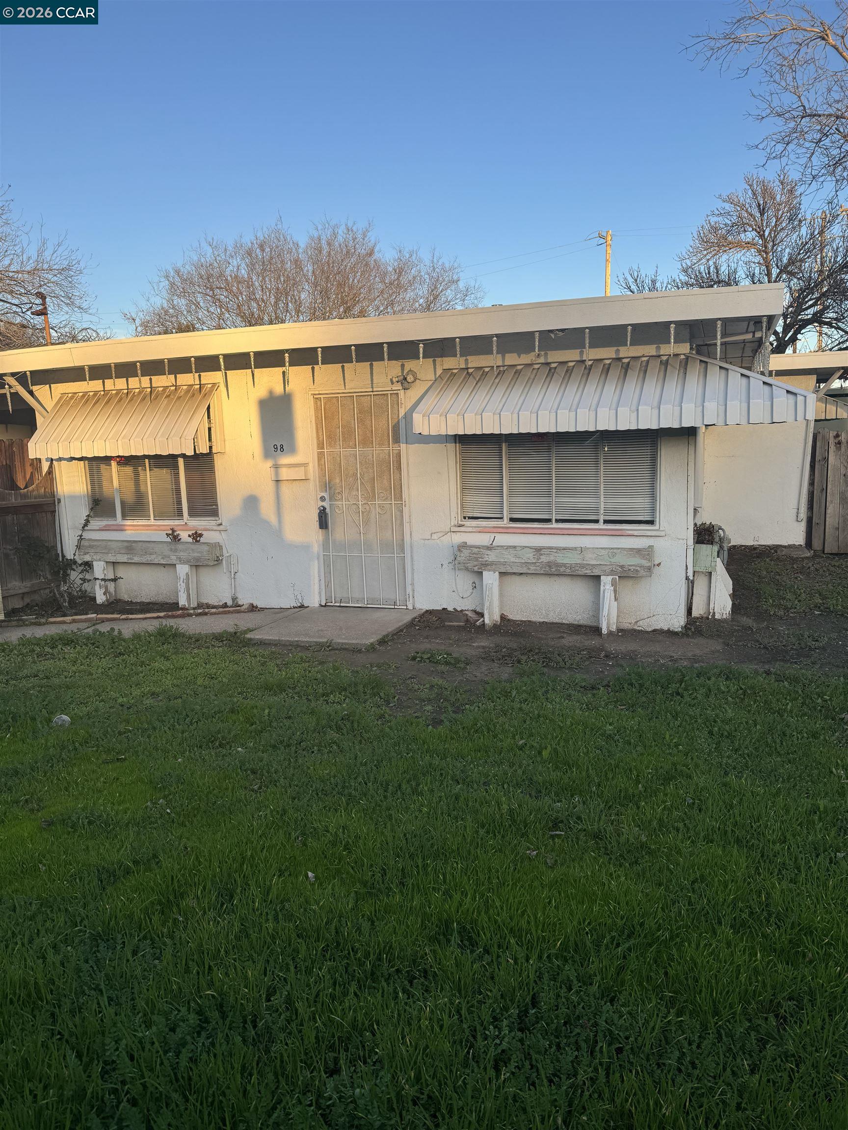a front view of a house with a yard and lake view