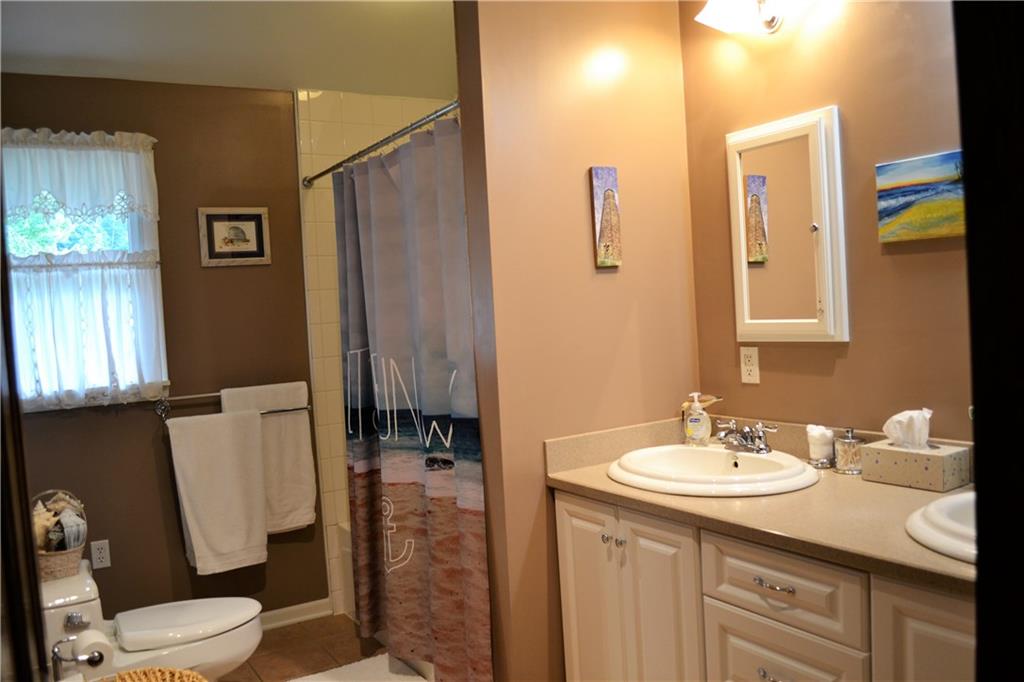 119 Pine Tree Road Kittanning, PA 16201 - Photo 17 of 25 Updated bathroom with double vanity, ceramic tile, vaulted ceilings, and tile surround