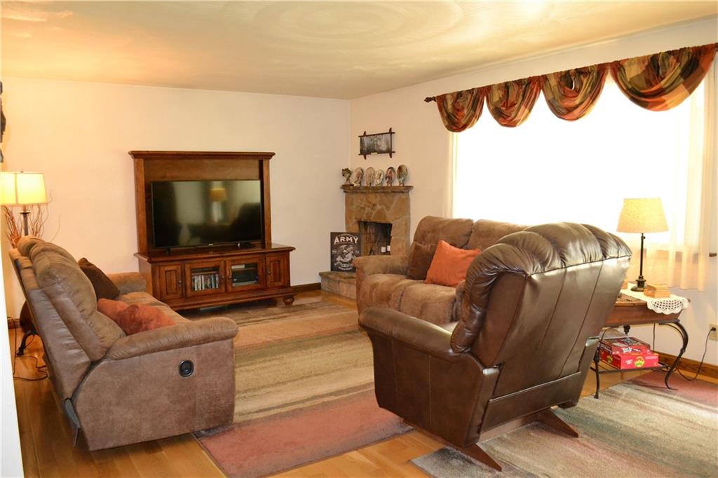 119 Pine Tree Road Kittanning, PA 16201 - Photo 6 of 25 The living room features a large picture window, hard wood floors, and a wood burning fireplace