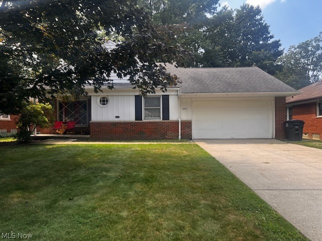 1192 Blanchester Road Cleveland, OH 44124 - Photo 2 of 2 View of front of home featuring brick siding, a garage, driveway, and a front lawn
