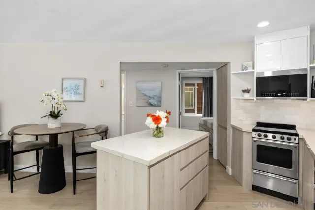 a kitchen with a stove a microwave and furniture