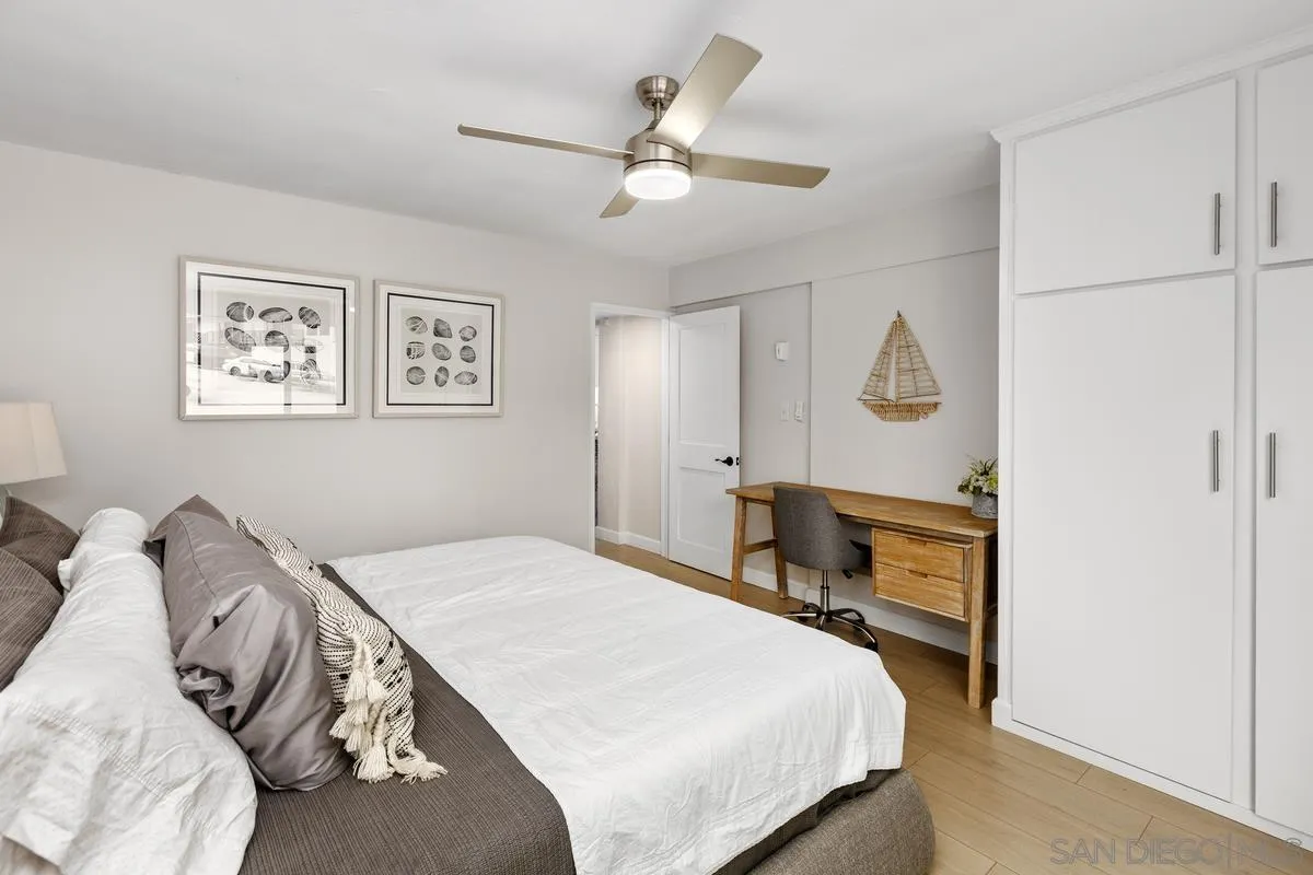 8040 Girard Avenue, Unit 2 La Jolla, CA 92037 - Photo 17 of 27 a bedroom with a bed and a chandelier