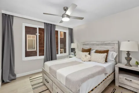 a bedroom with a large bed and a chandelier fan