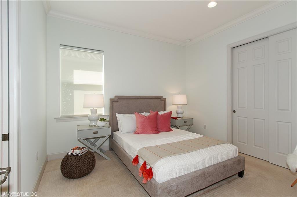 9293 Quarry Drive Naples, FL 34120 - Photo 12 of 28 a bedroom with a bed and a table