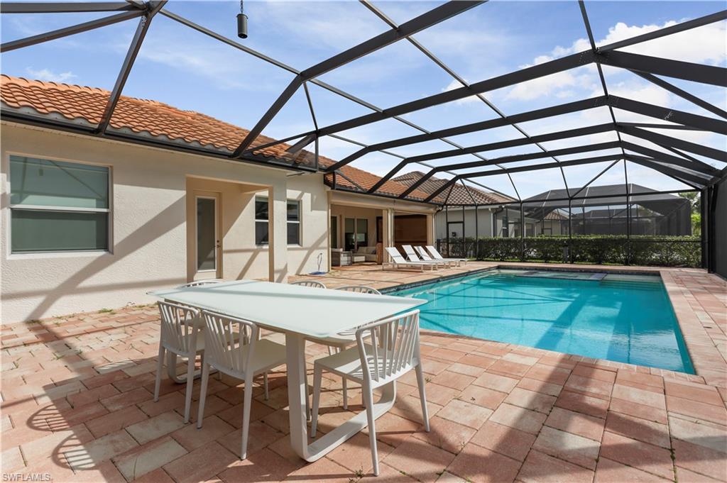 9293 Quarry Drive Naples, FL 34120 - Photo 19 of 28 a view of a patio with table and chairs with wooden floor