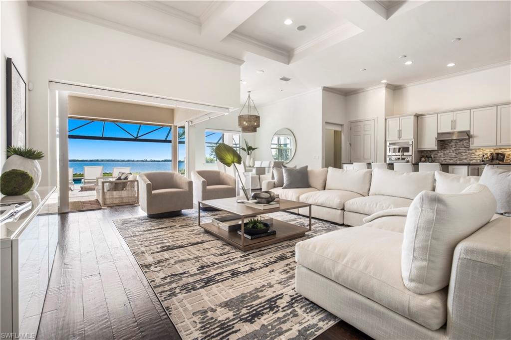 9293 Quarry Drive Naples, FL 34120 - Photo 2 of 28 a living room with furniture a rug and a chandelier