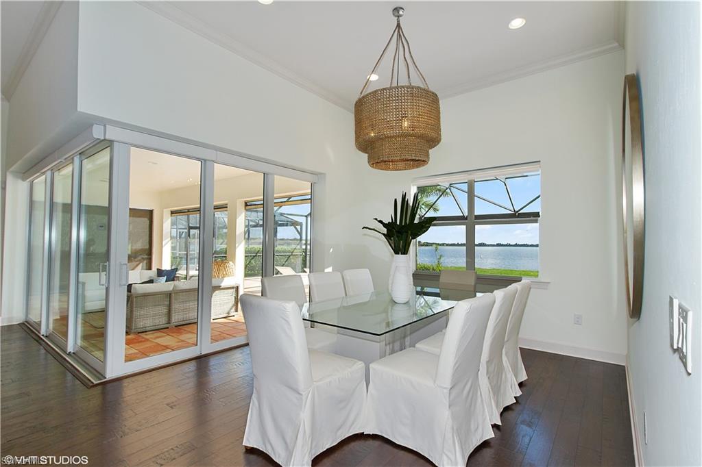 9293 Quarry Drive Naples, FL 34120 - Photo 6 of 28 a dining room with furniture a chandelier and wooden floor