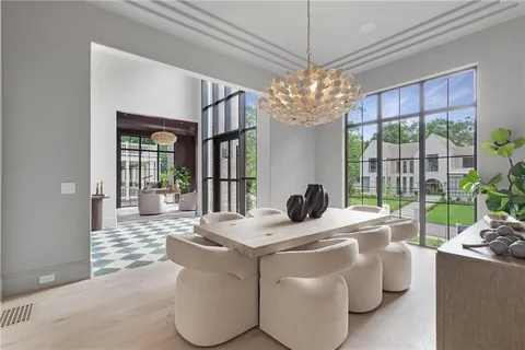 a living room with a black white checkered floor with couches chair and a coffee table