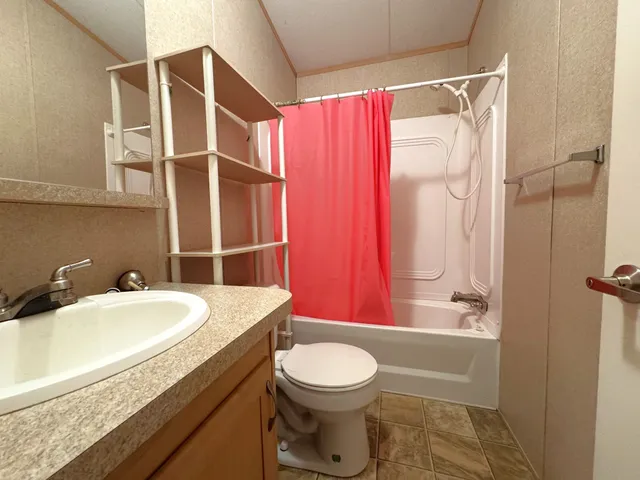 a bathroom with a sink a toilet and shower curtain