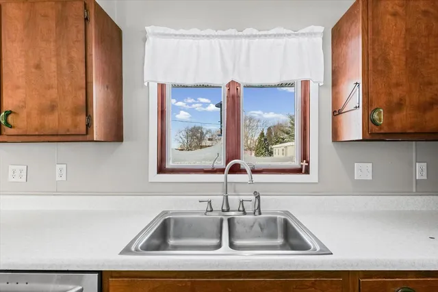 a kitchen with stainless steel appliances granite countertop a refrigerator a stove and a sink with wooden floor