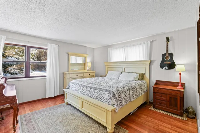 a bedroom with a bed and wooden floor