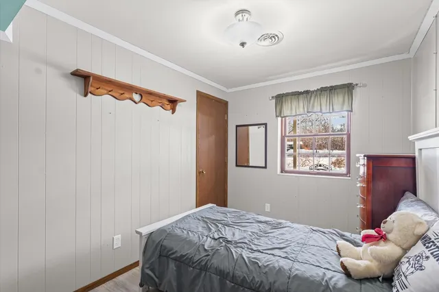 a bedroom with a dresser and chandelier