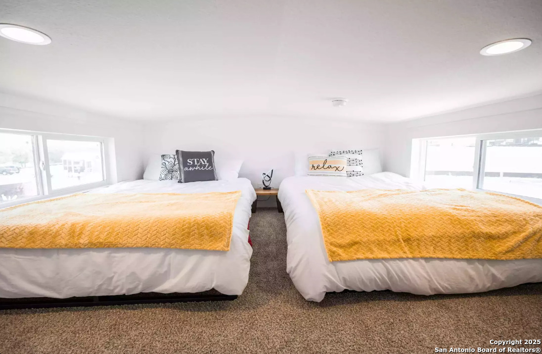 5386 Ranch Road 1376, Unit 114 Fredericksburg, TX 78624 - Photo 16 of 29 a large bed sitting in a bedroom next to a window