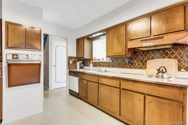 a kitchen with stainless steel appliances granite countertop a sink a stove and refrigerator