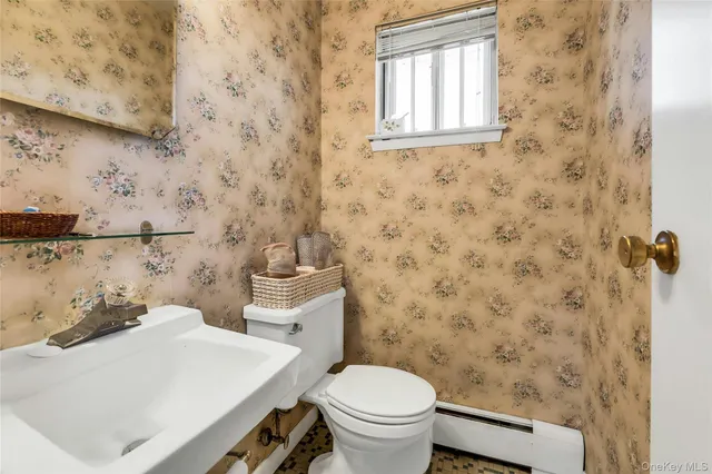 a bathroom with a sink a toilet and a window