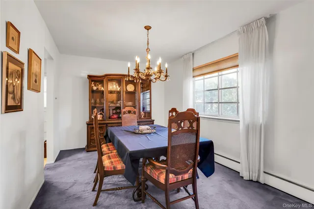a dining room with furniture a chandelier and wooden floor