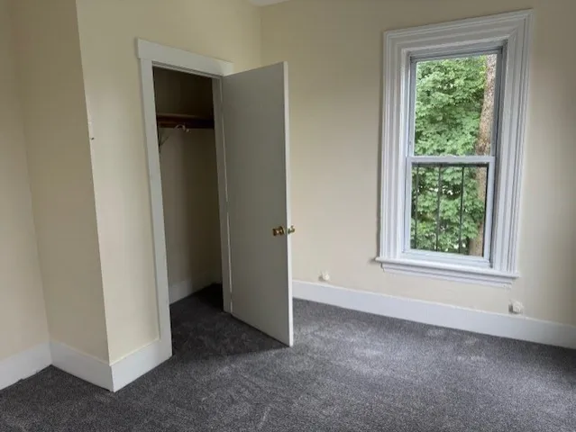 an empty room with windows and closet