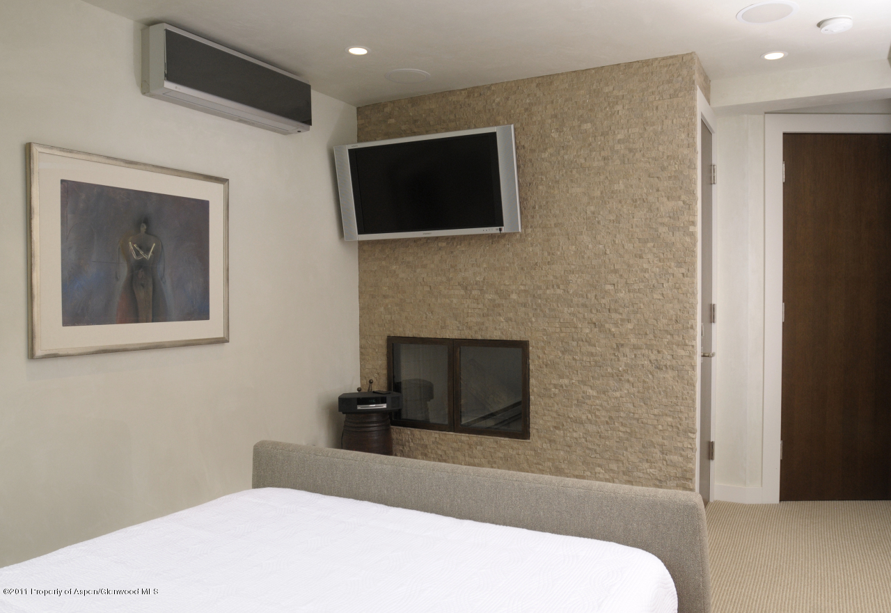 701 South Monarch Street, Unit 2 Aspen, CO 81611 - Photo 8 of 13 a bedroom with a bed and a flat screen tv