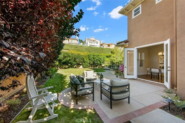 a view of a patio with couches table and chairs and potted plants